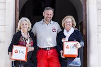 Volontarie FAI all'Istituto Superiore Antincendi | Foto Stefano Dal Pozzolo, 2024 © FAI Due signore volontarie FAI con in mano le scatole con il logo FAI e in mezzo a loro un pompiere con polo e pantaloni della divisa